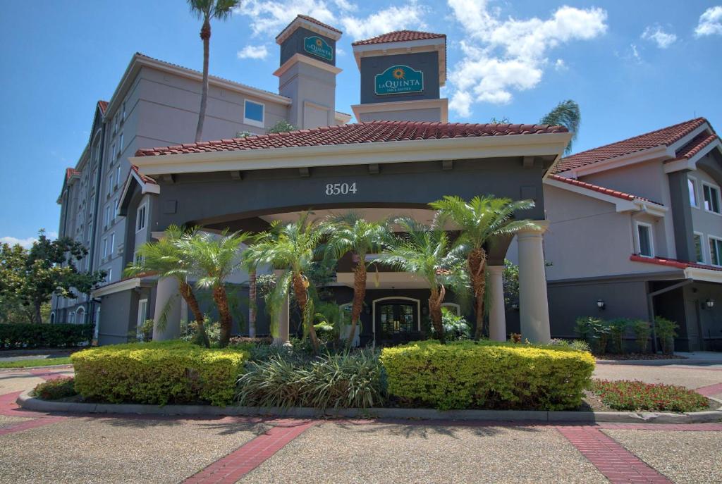 奥兰多奥兰多自行驾驶中心拉昆塔套房酒店的酒店大楼设有钟楼和棕榈树