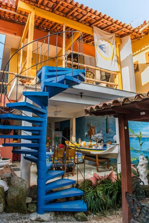 帕拉蒂Pousada Casa do Rio Hostel - 8 min do Centro Hístorico - Passeio de Barco com saída da Pousada -Pago a parte- Perto das Praias e Beira Rio的通往带船屋的蓝色楼梯