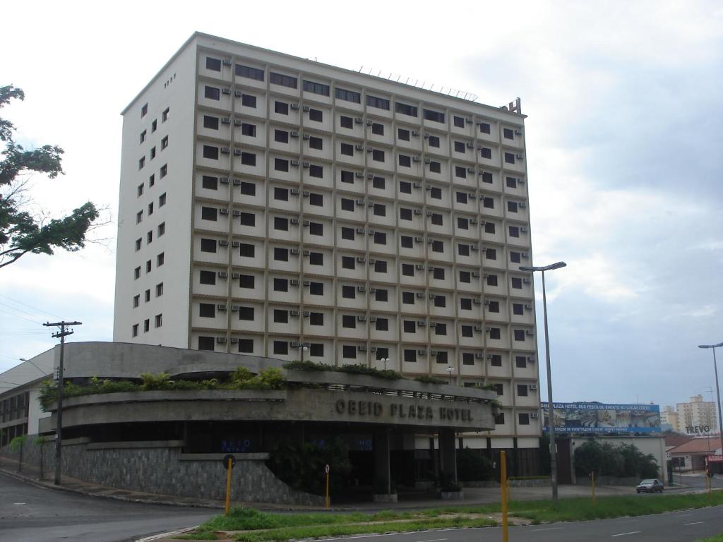巴乌鲁Obeid Plaza Hotel的前面有标志的高大的白色建筑