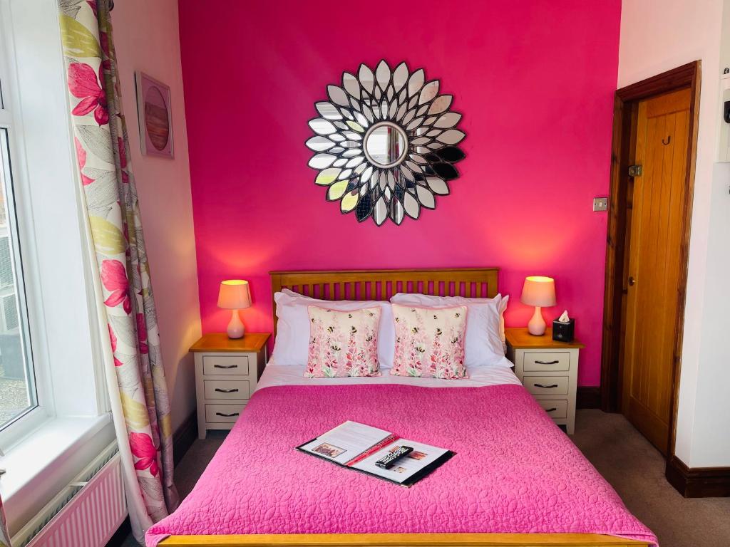 RiseThe Railway Inn的粉红色的卧室配有粉红色的床和镜子