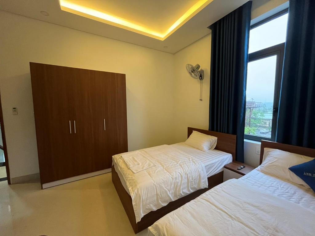 广义Nhà Nghỉ Ánh Dương的酒店客房设有两张床和窗户。