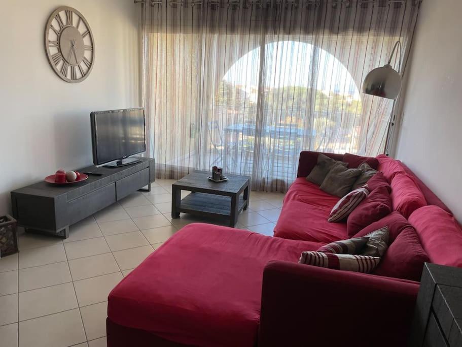 利勒鲁斯Appartement T3 Les eucalyptus的客厅配有红色沙发和电视