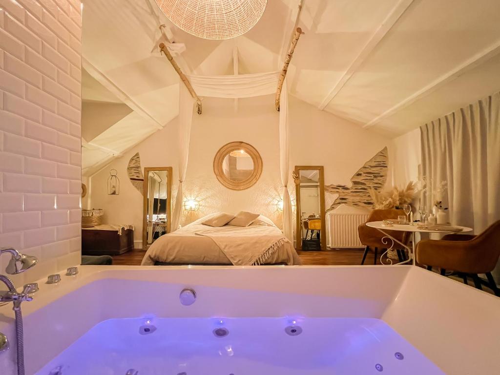 昂热Love Room Bohème Les Petits Plaisirs的卧室前设有带大浴缸的浴室