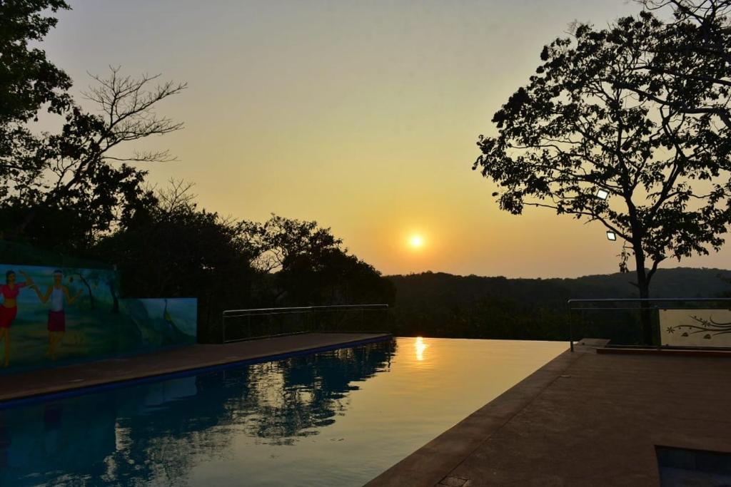 波戈马洛santanas wooden cottages的一座享有日落美景的游泳池
