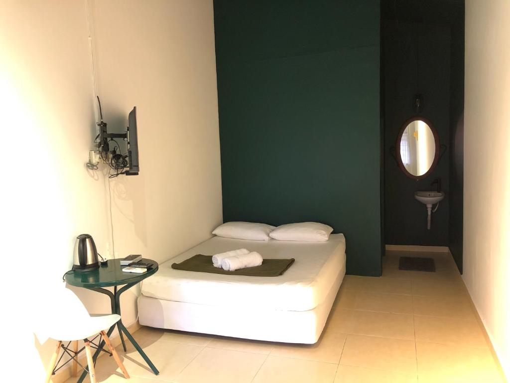 瓜拉丁加奴Rumah Tepi Istana的一间卧室配有一张床、一张桌子和一面镜子