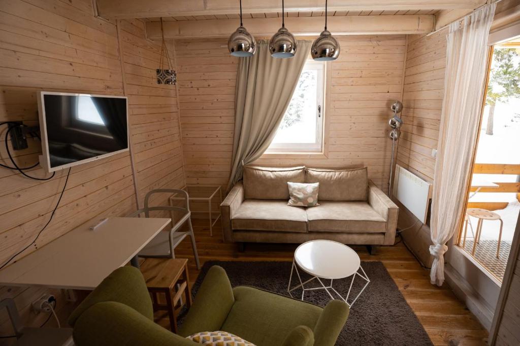 新瓦罗什ZlatAir Eco Chalet的带沙发和电视的小客厅