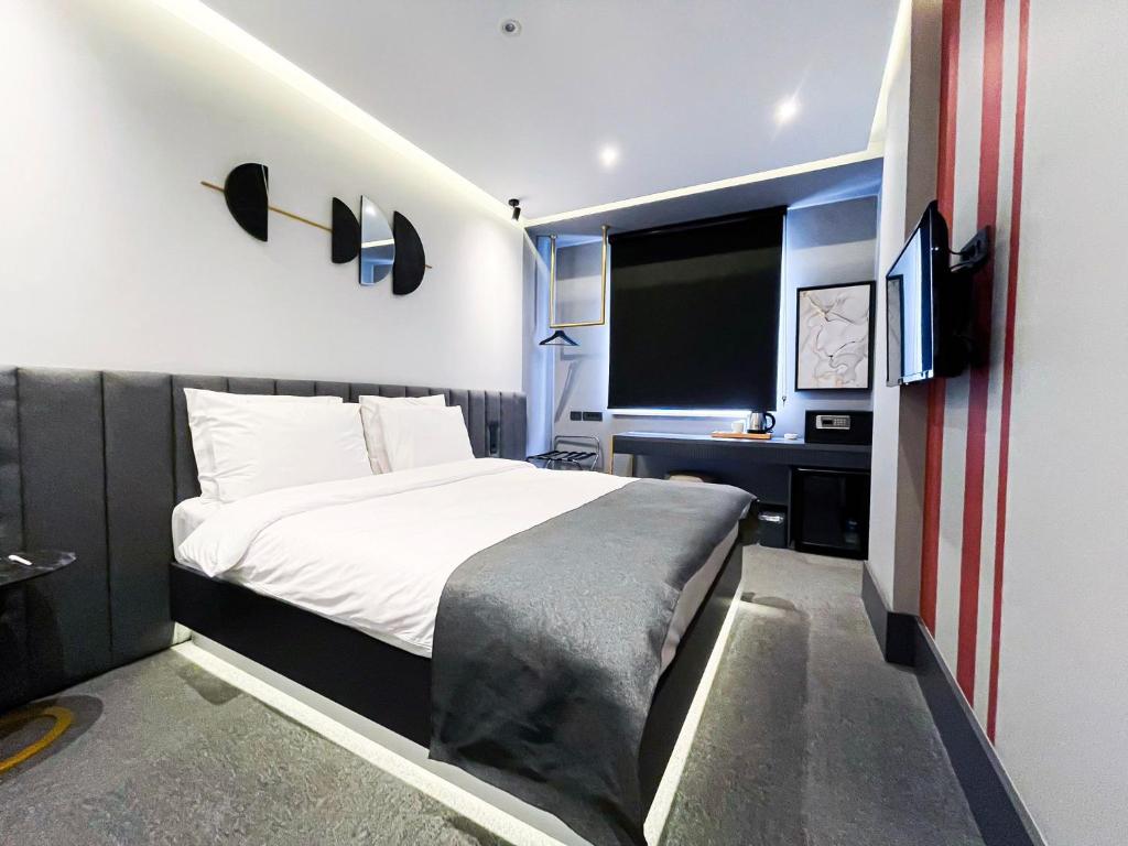 MELLDAY HOTEL的一间卧室配有一张大床和电视
