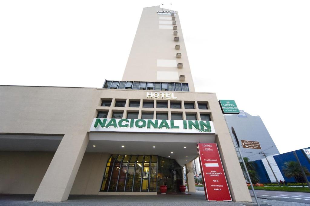 库里提巴Hotel Nacional Inn Curitiba Torres的一座白色的大建筑,上面有国线标志