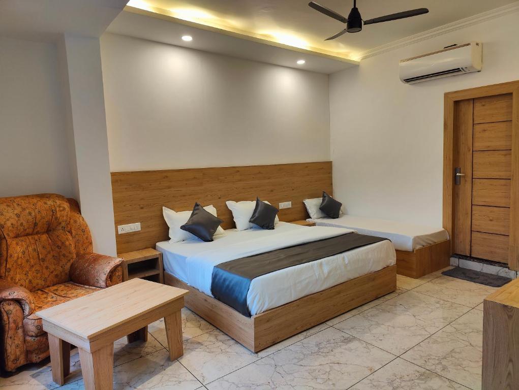 瑞诗凯诗Sonu Guesthouse & Hostel的一间卧室配有一张床、一把椅子和一张沙发