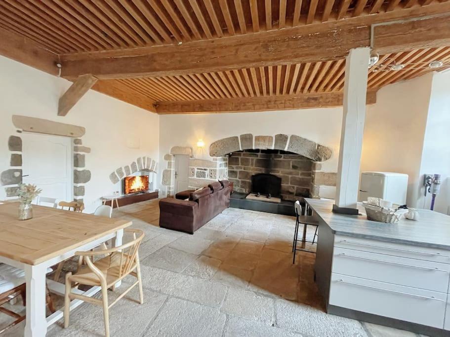勒布伊Logis du Chandelier的客厅配有桌子和壁炉