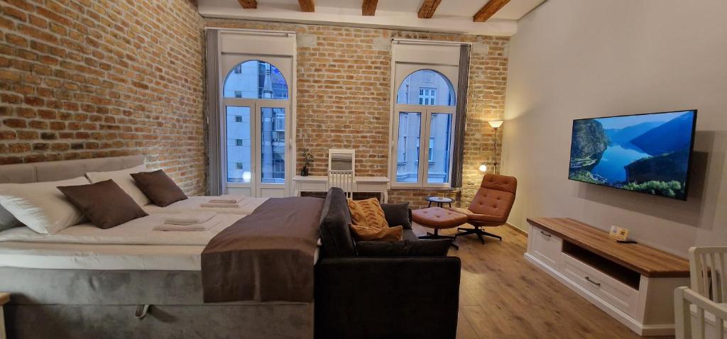 贝尔格莱德Old Town Apartments Rajiceva 3的一间卧室设有一张大床和砖墙