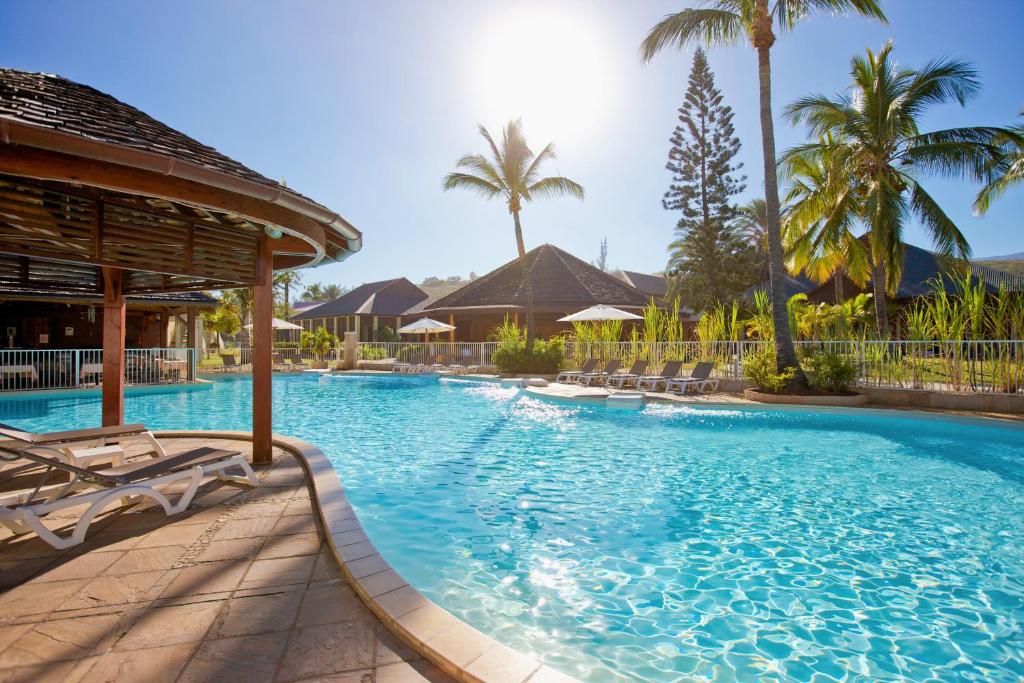 圣吉尔莱班留尼汪岛星礁度假村的一个带椅子和棕榈树的大型游泳池