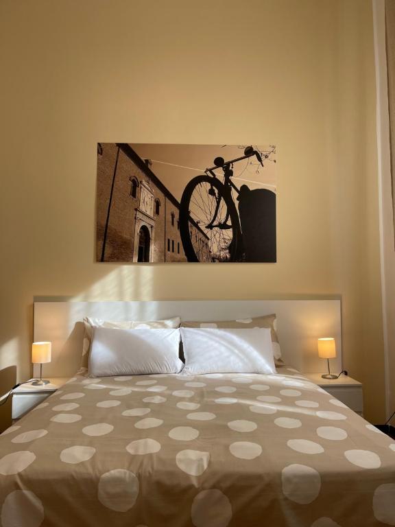 费拉拉Downtown - Camere in Centro的卧室配有一张床,墙上挂着自行车