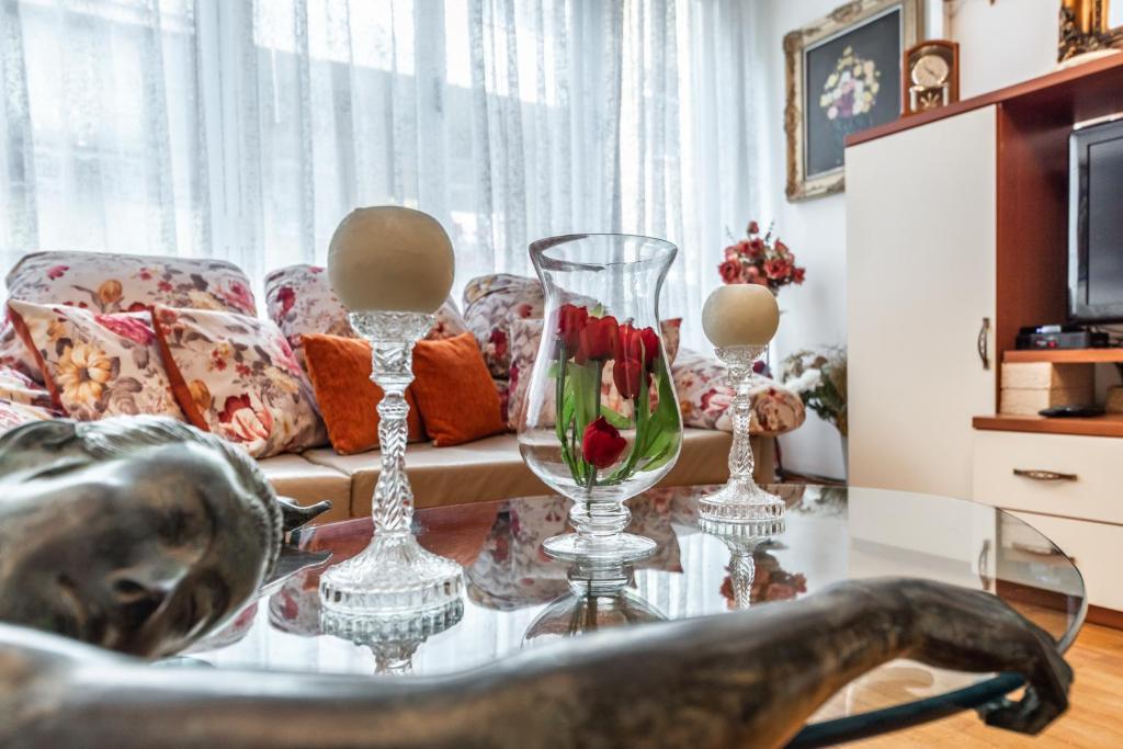 地拉那Vintage and warm 2BR apartament in Tirana的客厅配有带花瓶的桌子和沙发