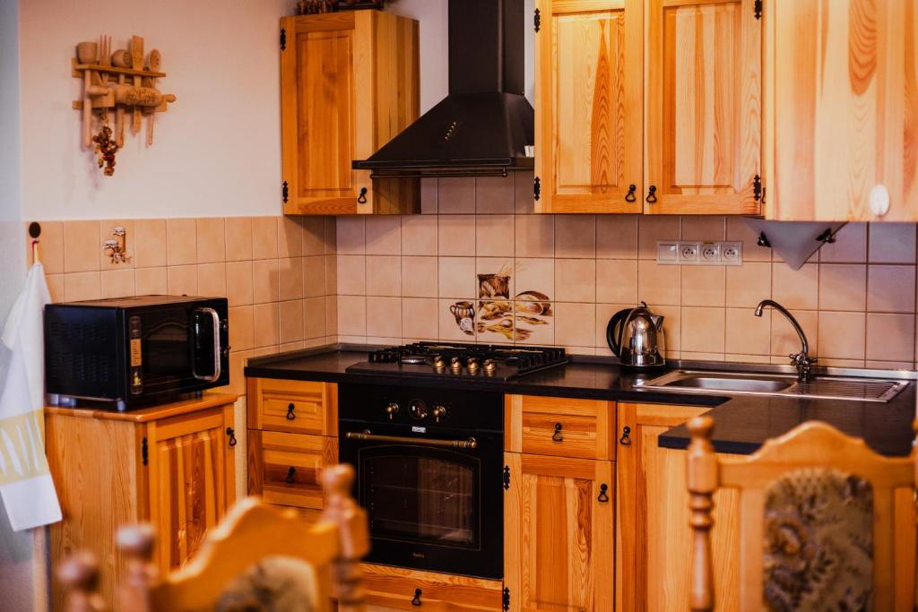 VavrišovoGazdov dvor的厨房配有木制橱柜和黑炉灶烤箱。