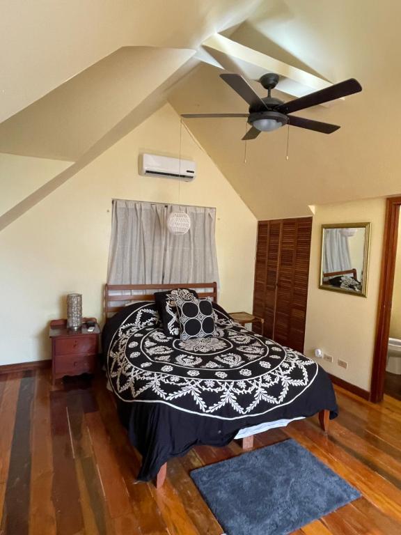 库尔克岛The Coral Casa的一间卧室配有一张床和吊扇