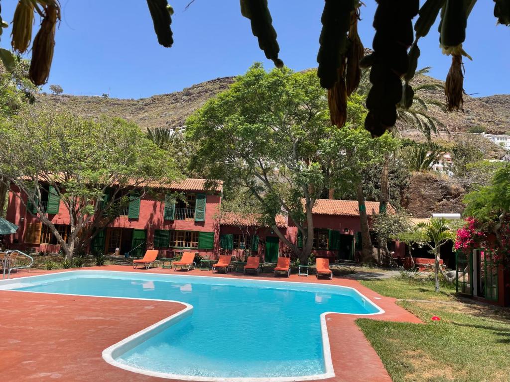 阿格特La Casa del Molino de Viento的度假村前方的游泳池,带椅子和树木