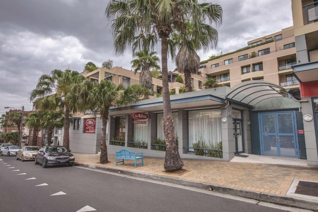 悉尼悉尼库吉海阿迪纳公寓式酒店的街道边有棕榈树的建筑