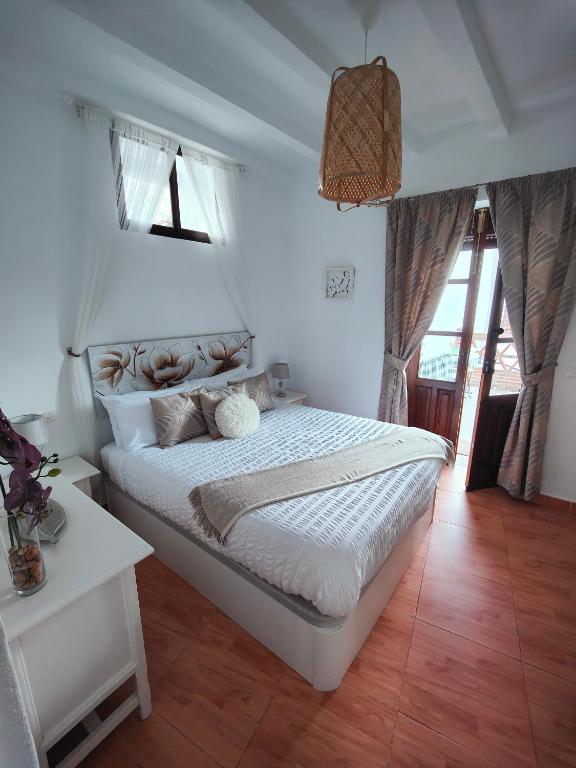 蒙特哈克Las Lajas, Casa Rural的卧室配有一张白色的大床和一张桌子