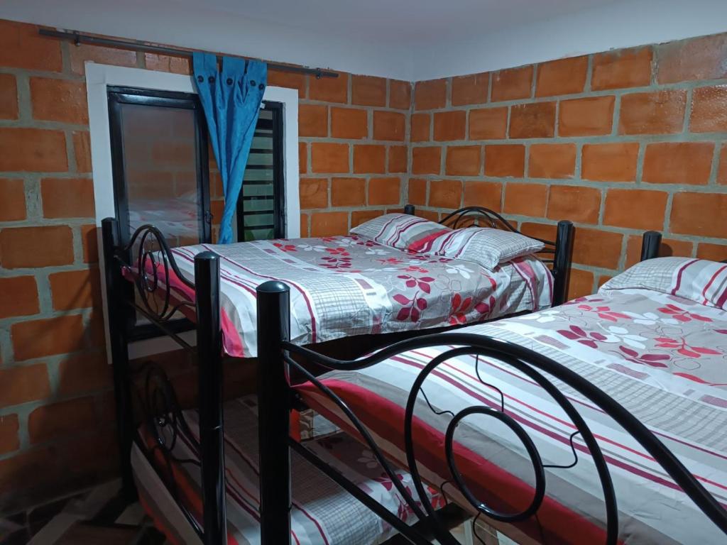 RozoVILLA BRAULIO的砖墙客房中的两张双层床