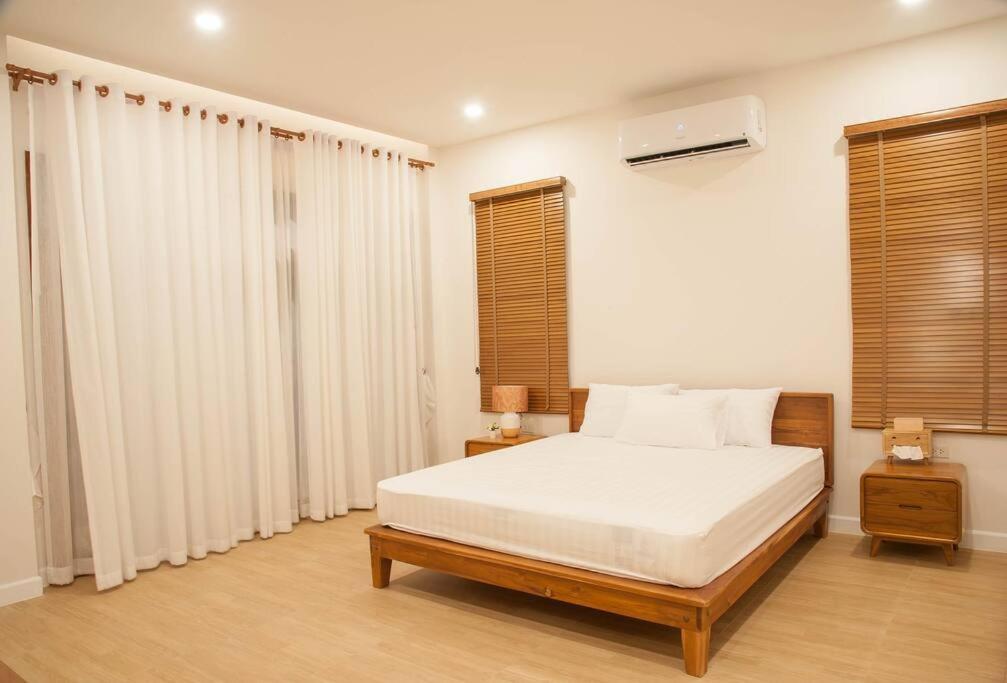 哈德超珊兰Chao Sam Ran Pool Villa Phetchaburi หาดเจ้าสำราญ เพชรบุรี ราคาสำหรับ 8 ท่าน的一间卧室配有一张带白色床单和窗户的床。