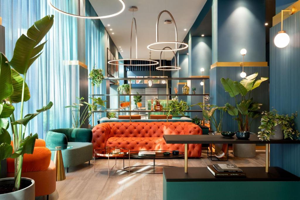 米兰Duo Milan Porta Nuova, a Tribute Portfolio Hotel的客厅配有橙色沙发和植物
