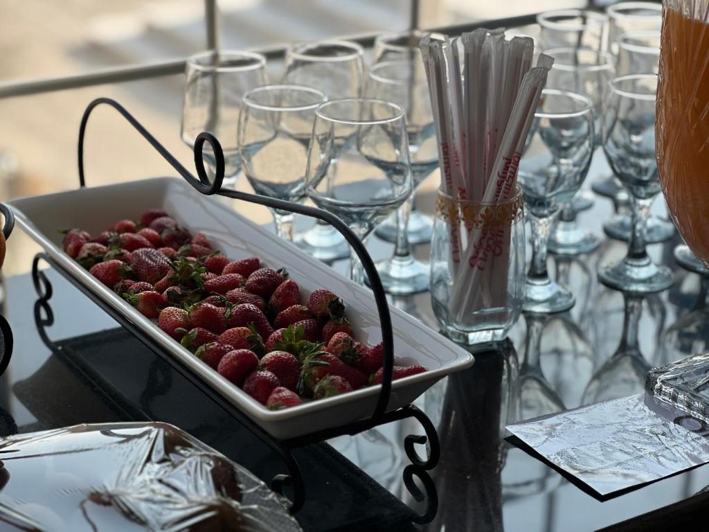 卡拉尔哥特Hotel Hayatt Sukkur的桌子上放着草莓的托盘,上面放着眼镜