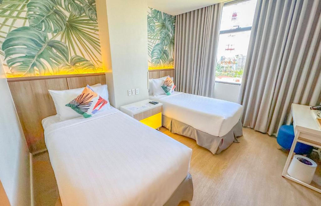 马尼拉Harolds Evotel Quezon City的酒店客房设有两张床和窗户。