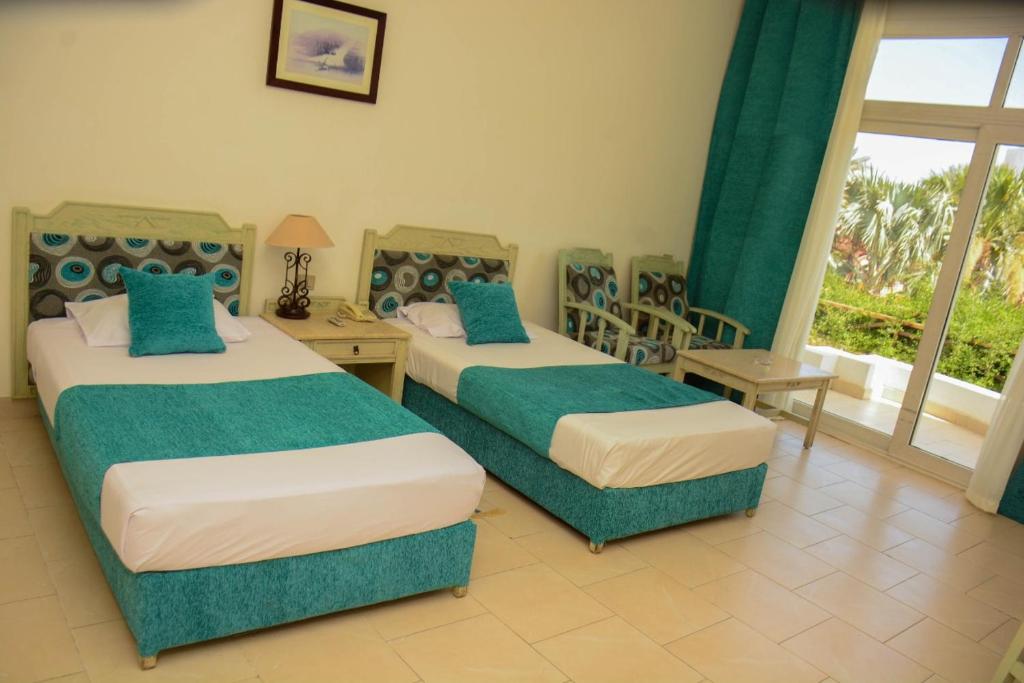 沙姆沙伊赫Queen Sharm Italian Club的酒店客房设有两张床和窗户。