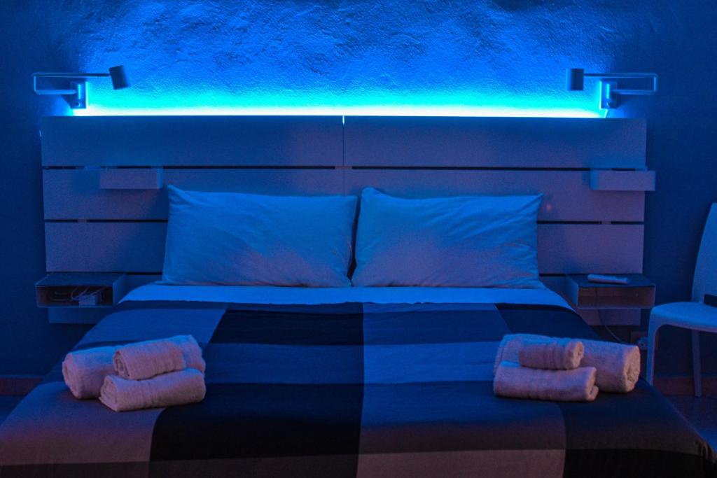 切法卢Sikelia House Cefalù的一间卧室配有一张蓝色灯床