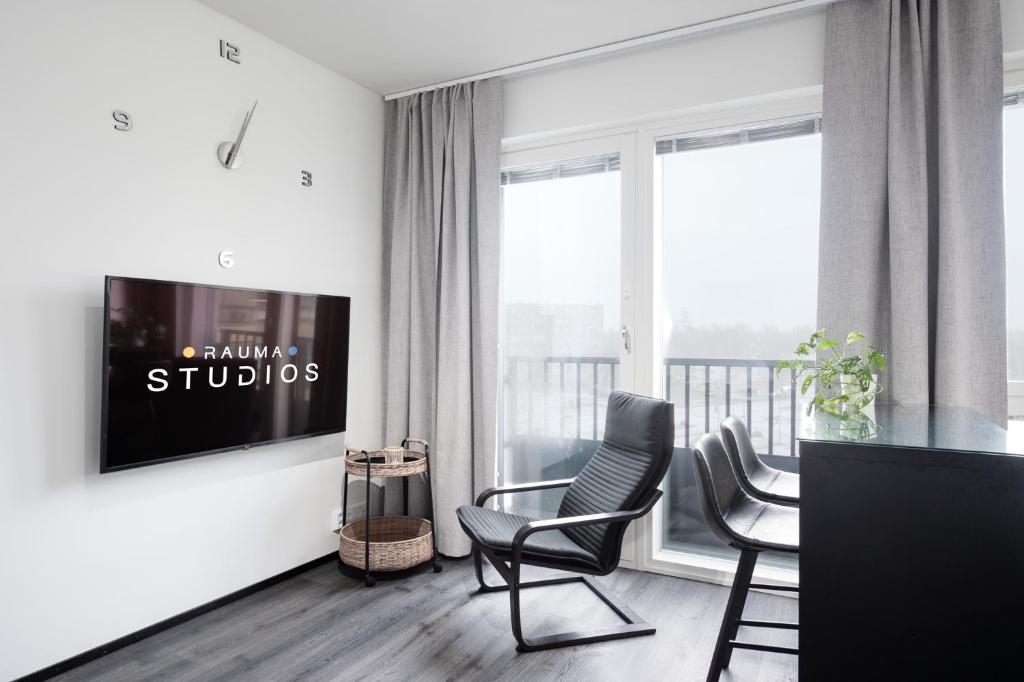 劳马Rauma City Center Studios的客厅配有椅子和墙上的电视