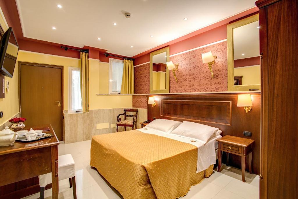 罗马奥勒留艺术画廊酒店的一间卧室配有一张床、一张桌子和一张书桌