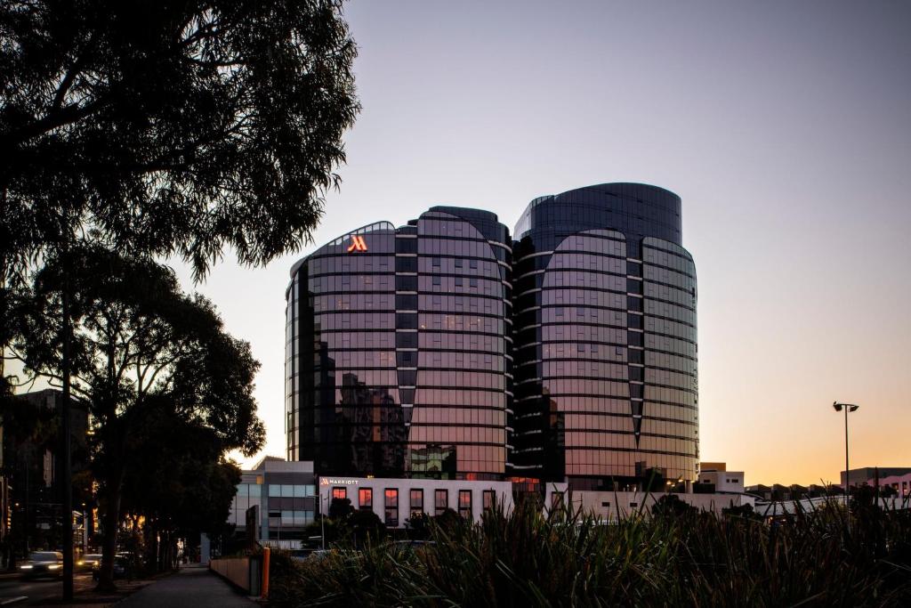 墨尔本Melbourne Marriott Hotel Docklands的日落时分城市的两座高楼