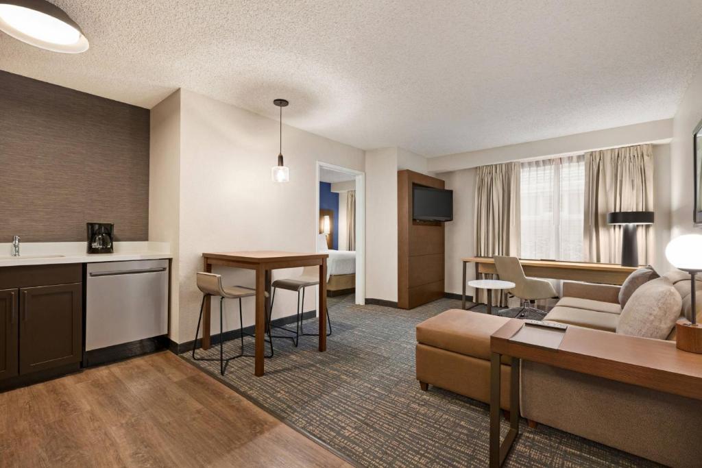 诺福克诺福克机场原住客栈 的一间客厅,客厅配有沙发和一张桌子,位于酒店的房间