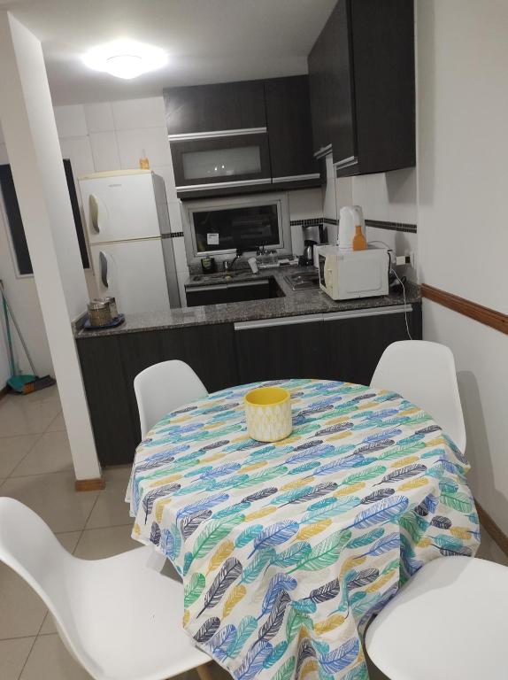 布宜诺斯艾利斯Depto Directorio的厨房配有桌子、白色椅子和冰箱