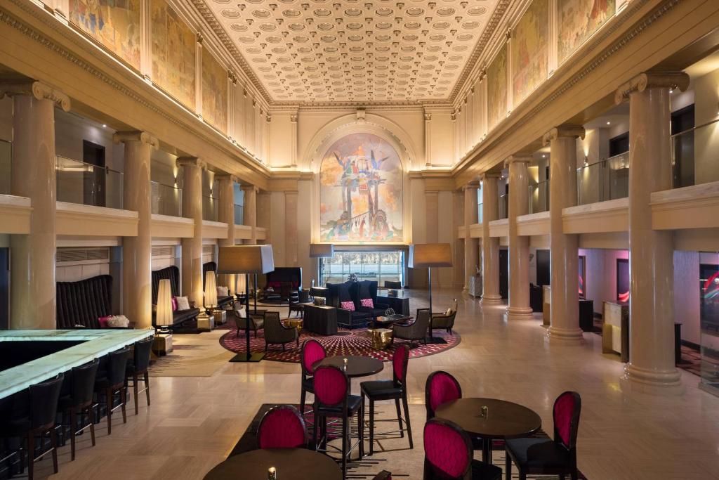 丹佛丹佛市中心万丽酒店的大堂设有桌椅和天花板上的绘画作品