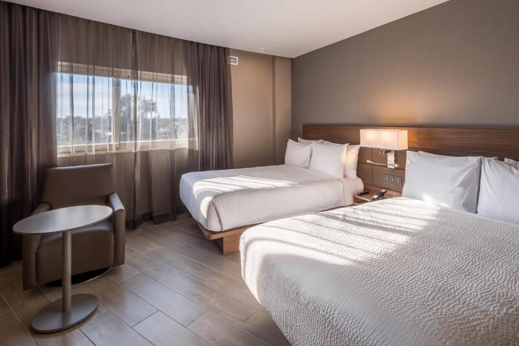 瓜达拉哈拉AC Hotel by Marriott Guadalajara Expo的酒店客房设有两张床和窗户。