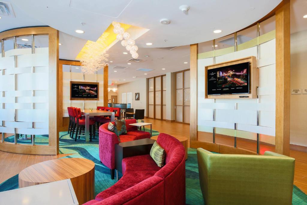 圣何塞圣何塞机场春季山丘套房酒店的大堂设有红色椅子和用餐室