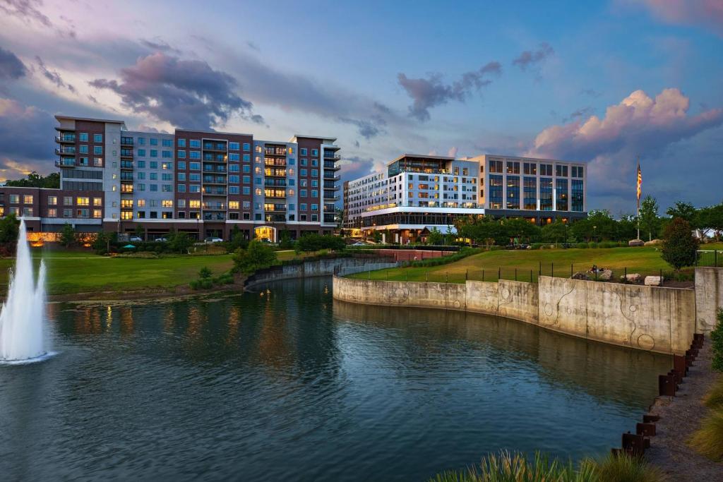 塔拉哈西AC Hotel by Marriott Tallahassee Universities at the Capitol的享有河流美景,设有建筑和喷泉