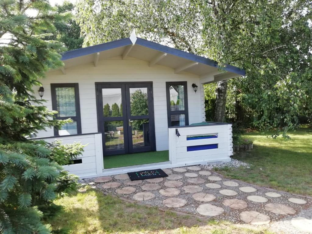 斯维诺乌伊希切Domek letniskowy SZUWAREK的蓝色屋顶的白色小棚子