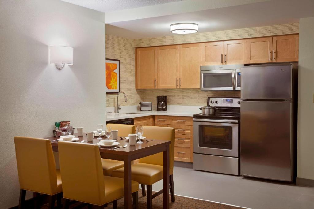 马卡姆Residence Inn by Marriott Toronto Markham的厨房配有带黄椅和不锈钢用具的桌子