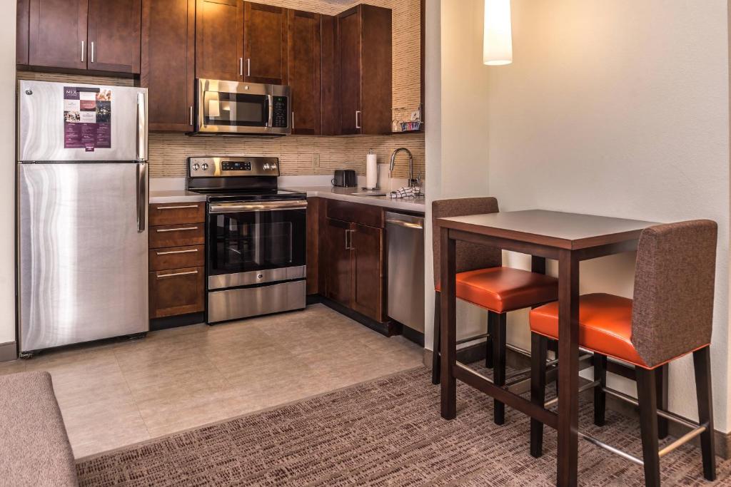 马里兰高地Residence Inn by Marriott St. Louis Westport的厨房配有不锈钢用具和桌子