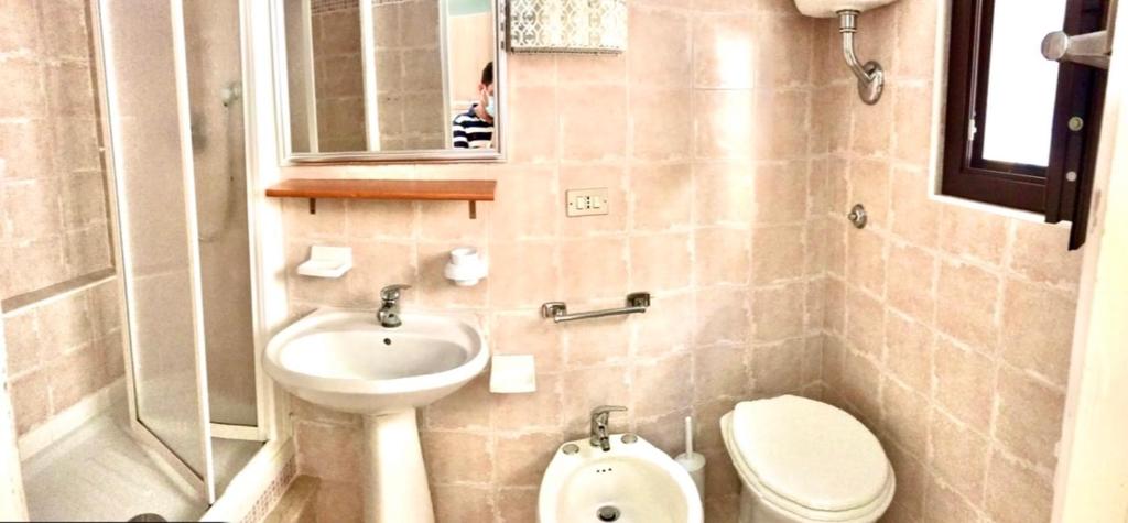 切法卢Carbonari Holiday House的一间带水槽、卫生间和镜子的浴室