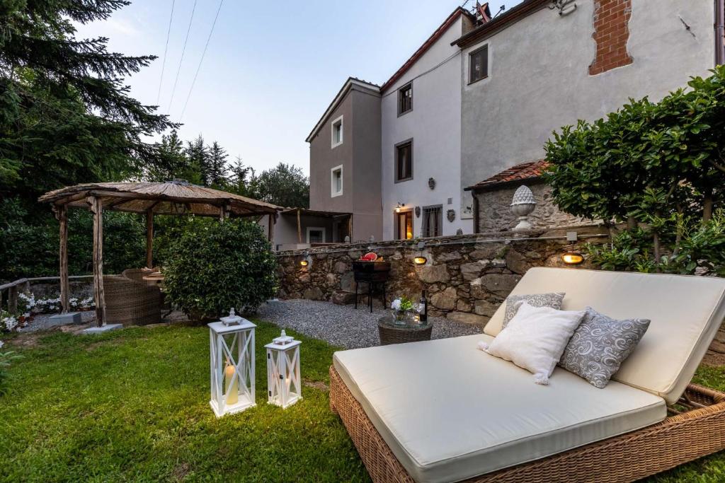 卡潘诺里Rio delle Fate, a Fairytale Home along the Stream in Vorno, Lucca的坐在院子里的草上的一个白色沙发