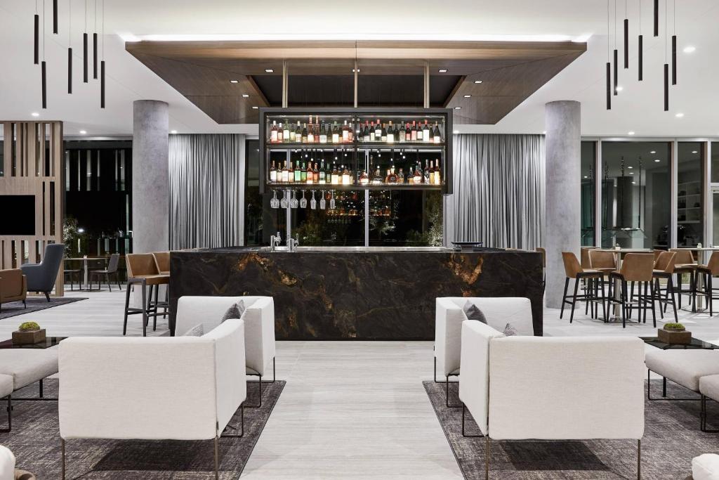 凤凰城AC Hotel Phoenix Biltmore的酒店大堂设有带白色椅子的酒吧