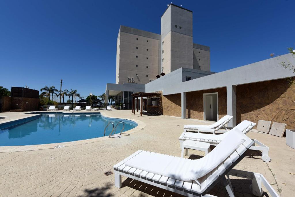 拉马约Camberland Resort & Spa Ramallo的一座游泳池旁设有两把躺椅