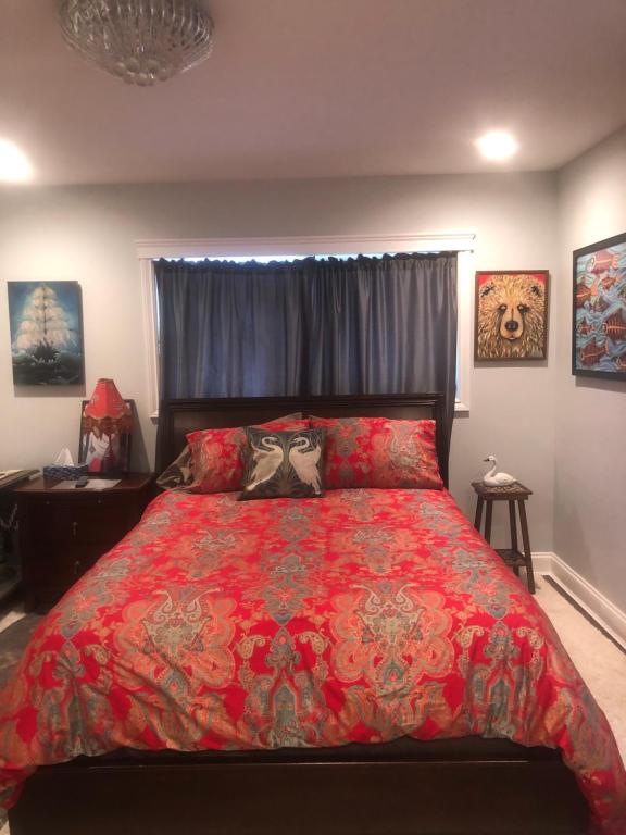 甘奇斯Raven's Cache Bed and Breakfast的一间卧室配有一张大床和红色的被子