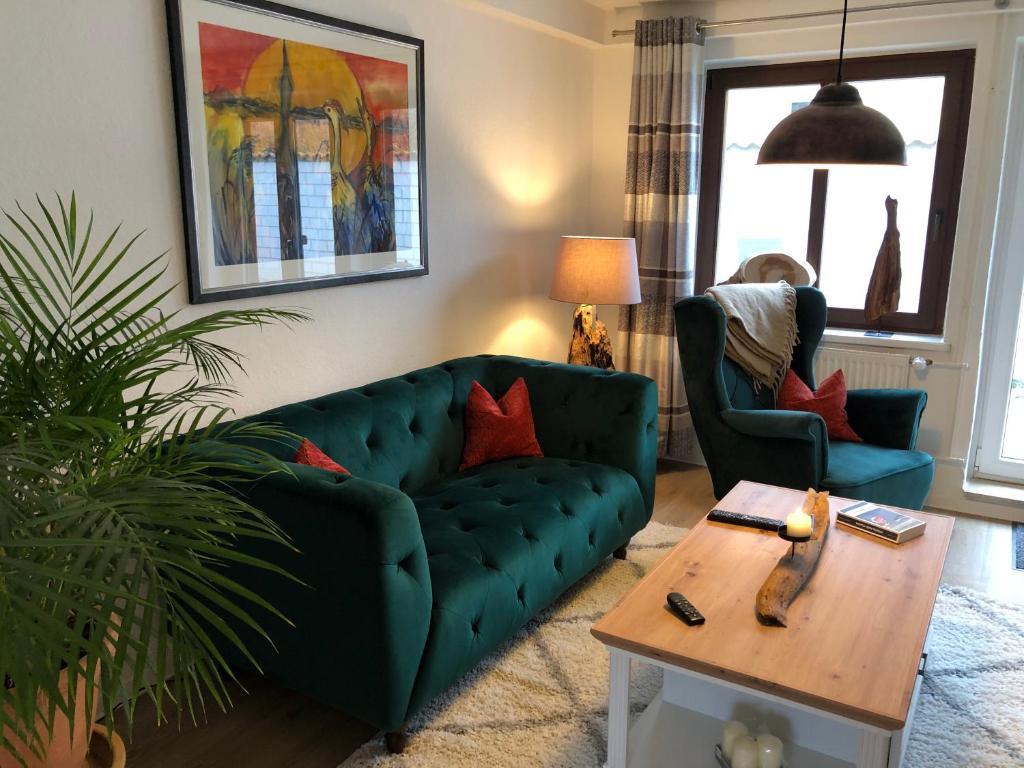 欧巴德伍斯图Treibholz的客厅配有绿色沙发和桌子