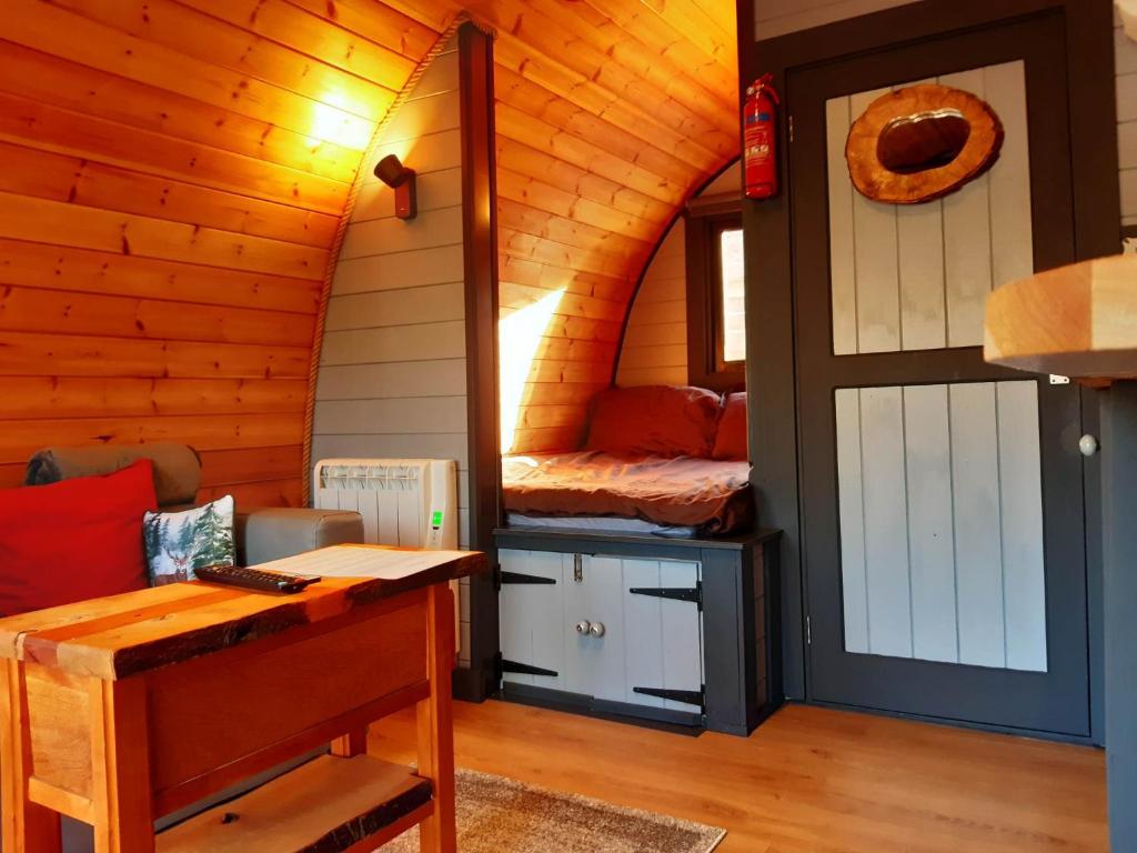 金洛赫利文Coe Pod, West Highland Way Holidays的小屋内带一张床和一张书桌的房间