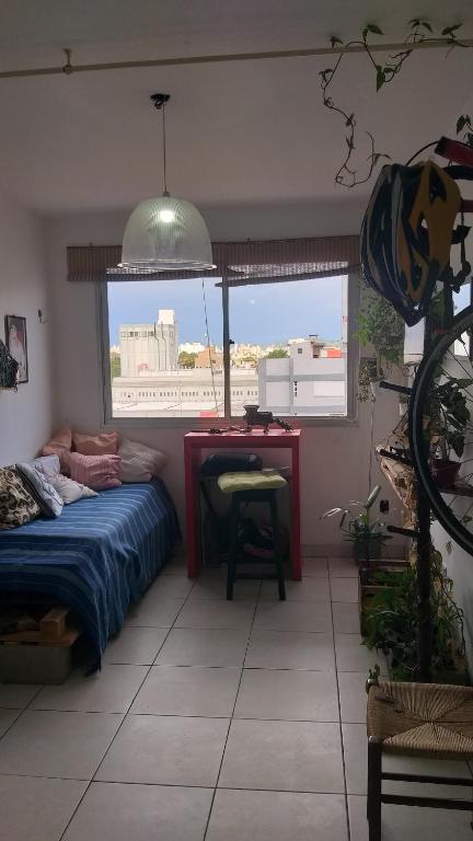 阿雷格里港Apto do Thiago e da Chori的一间卧室配有一张床、一张书桌和一个窗户。